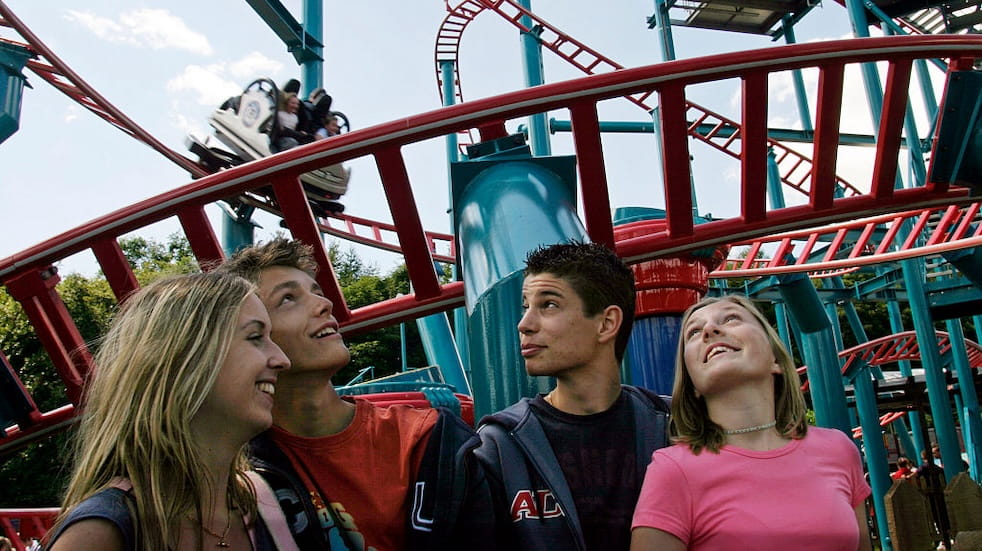 Teenagers in a queue for the Spinball Whizzer ride at Alton Towers Amusement Park, Alton, UK